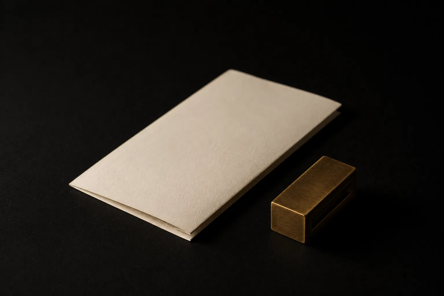 Folded bone paper beside a brass type slug